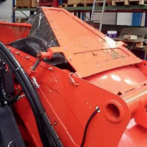 Deflector hidráulico de salida del transportador para guiar la proyección del producto