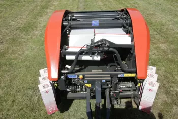 Dos rodillos normales de plástico elástico de 750 mm atando una paca