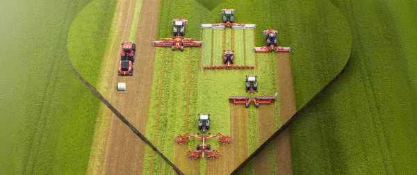 Das Keyvisual der KUHNaktuell. Herbstrasen 2026 - Frühbezug, welches verschiedene Futtererntemaschinen im Einsatz zeigt.