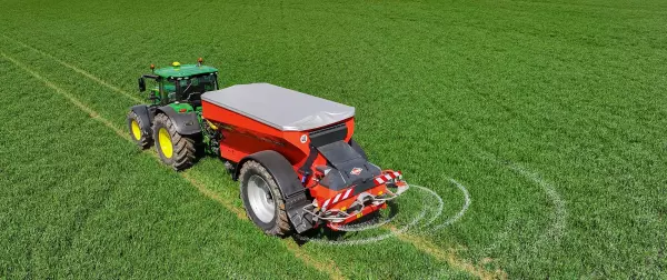 L'épandeur d'engrais traîné AXENT qui distribue l'engrais au champs 